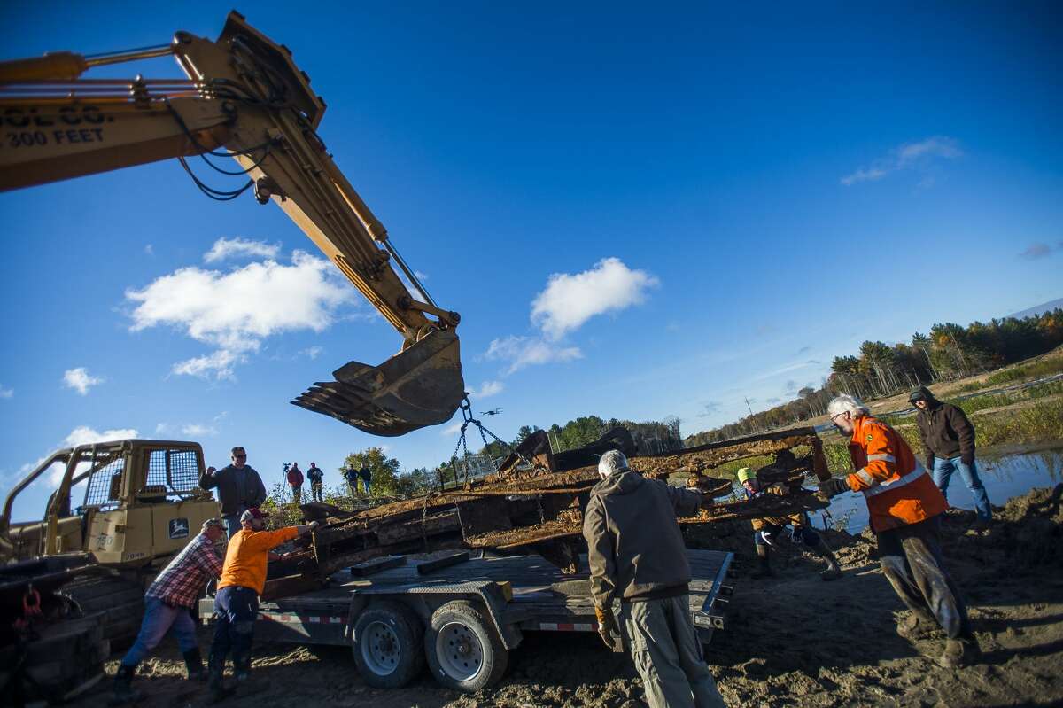 A group of volunteers led by Mike Oberloier of Beaverton work to remove a steam-powered shovel from the 1920s from the lakebed of Wixom Lake Saturday, Oct. 24, 2020 in Hope. (Katy Kildee/kkildee@mdn.net)