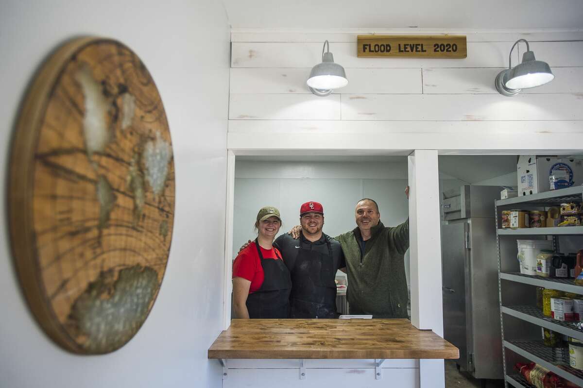 From left, Abbi Brady, Jack Brady and Mike Brady pose for a photo inside the business as it reopens Saturday, Oct. 24, 2020, for the first time since the building was damaged during the May 19 dam failures and flooding. (Katy Kildee/kkildee@mdn.net)