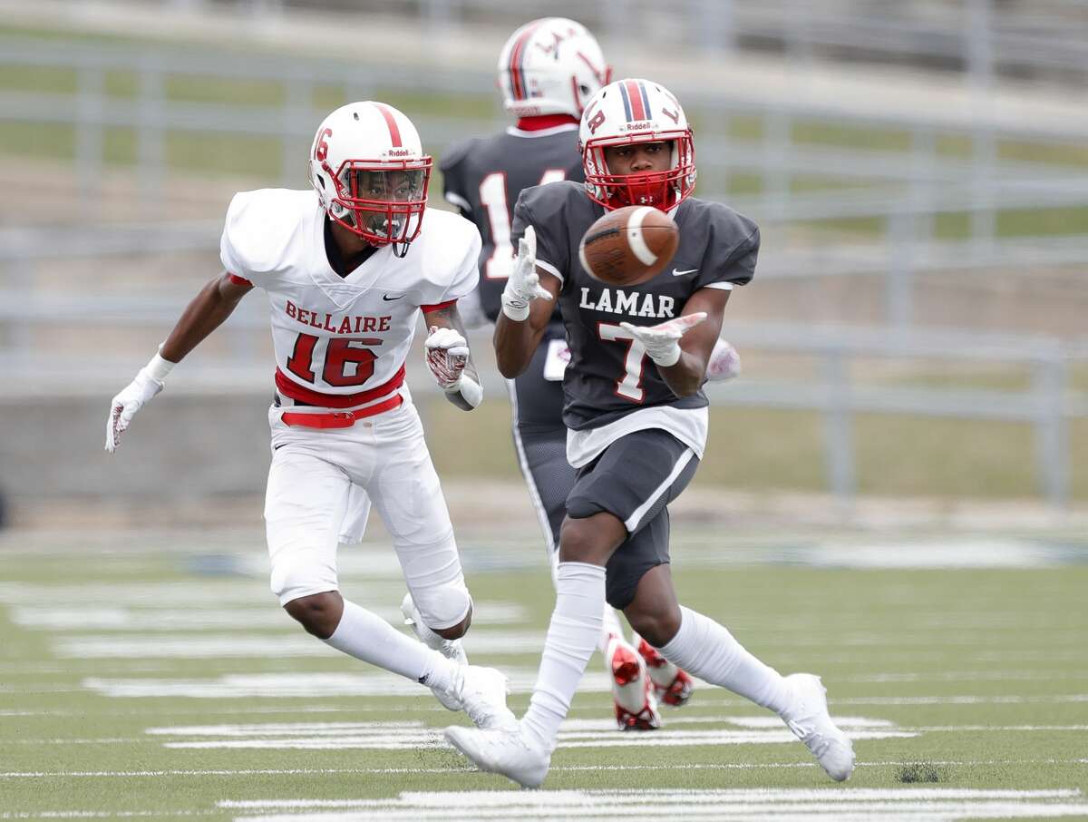 Lamar wide receiver Zachary Green (7) catches a pass as Bellaire linebacker Ty Bennett (16) defends during the first quarter of a District 18-6A high school football game at Delmar Stadium, Saturday, Oct. 24, 2020, in Houston.