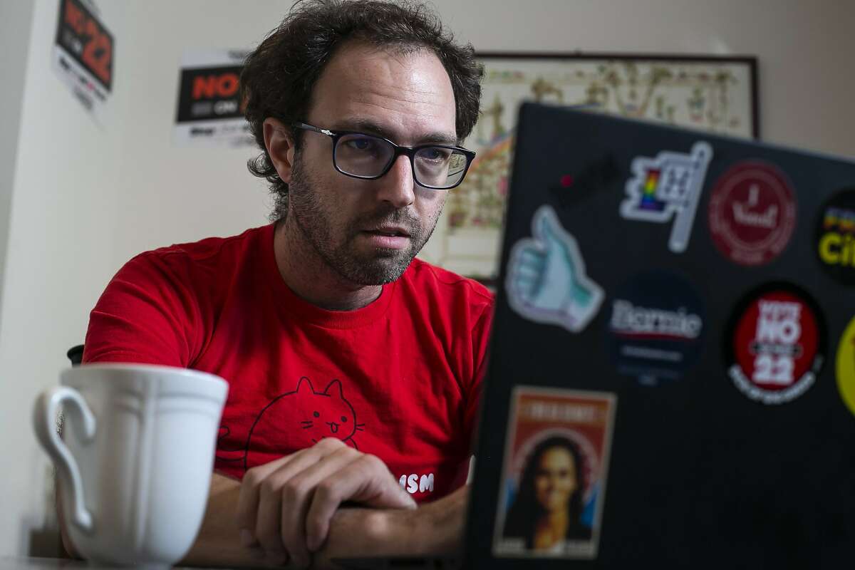 Tyler Breisacher, who delivers for DoorDash part time, works from his home sending text messages and making phone calls urging people to vote against Proposition 22. The measure would exempt ride-hail and food-delivery companies from AB5, a law that makes it hard to classify gig workers as independent contractors.