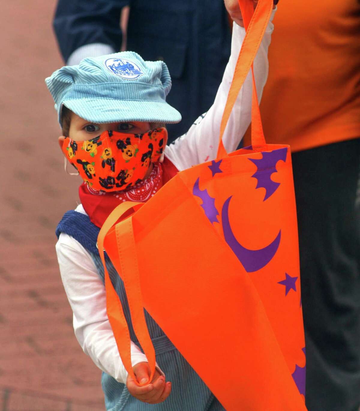 Leo Hicks, 3, of Milford, takes part in a safe, socially distant way to enjoy the Halloween holiday in downtown Milford, Conn., on Saturday Oct. 24, 2020. Sponsored by Spinnaker Milford, participating shops put a scarecrow out front and offered treats to local kids.