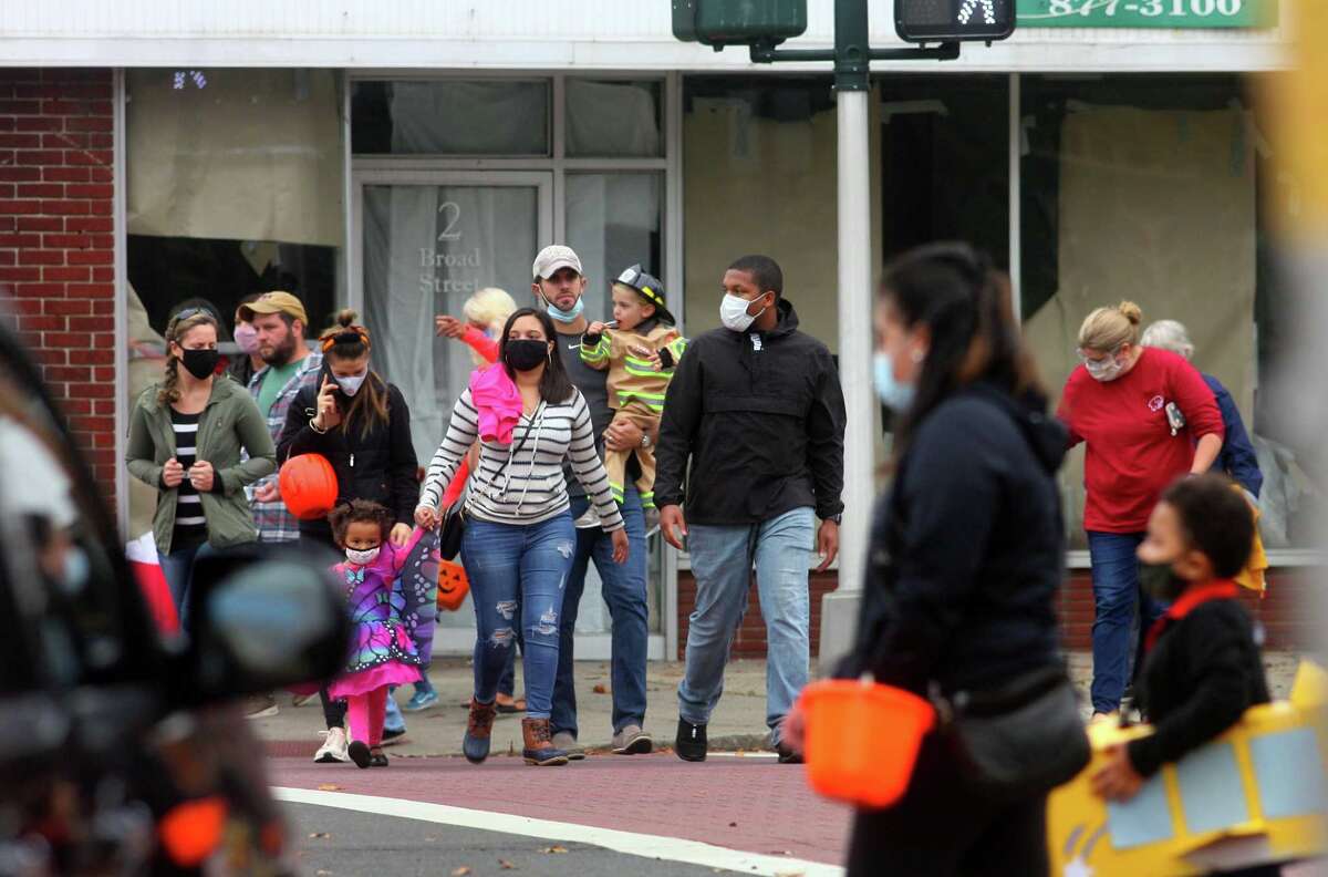 Local families wander through downtown Milford, Conn., taking part in a safe, socially distant way to enjoy the Halloween holiday on Saturday Oct. 24, 2020. Sponsored by Spinnaker Milford, participating shops put a scarecrow out front and offered treats to local kids.