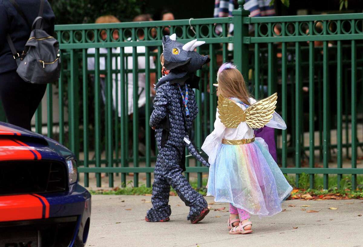 Local families wander through downtown Milford, Conn., taking part in a safe, socially distant way to enjoy the Halloween holiday on Saturday Oct. 24, 2020. Sponsored by Spinnaker Milford, participating shops put a scarecrow out front and offered treats to local kids.