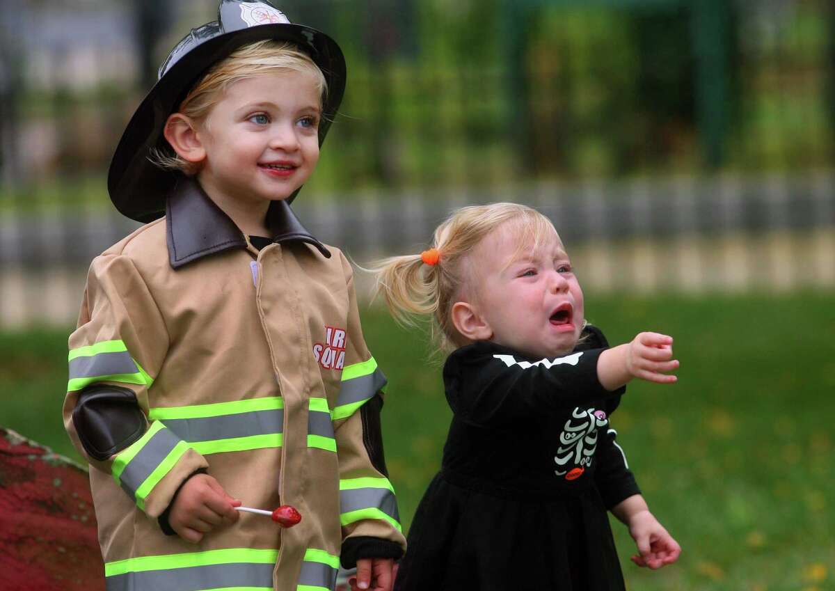 Local families wander through downtown Milford, Conn., taking part in a safe, socially distant way to enjoy the Halloween holiday on Saturday Oct. 24, 2020. Sponsored by Spinnaker Milford, participating shops put a scarecrow out front and offered treats to local kids.