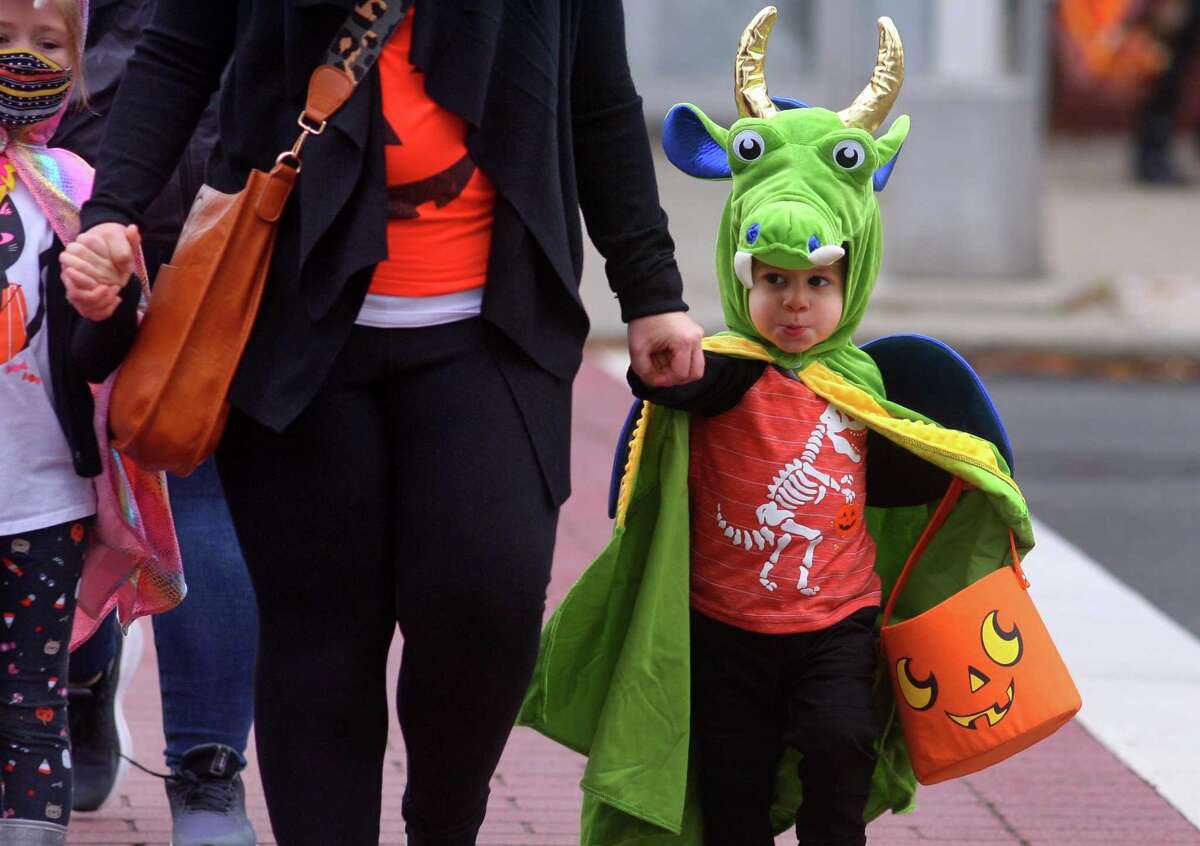 Local families wander through downtown Milford, Conn., taking part in a safe, socially distant way to enjoy the Halloween holiday on Saturday Oct. 24, 2020. Sponsored by Spinnaker Milford, participating shops put a scarecrow out front and offered treats to local kids.