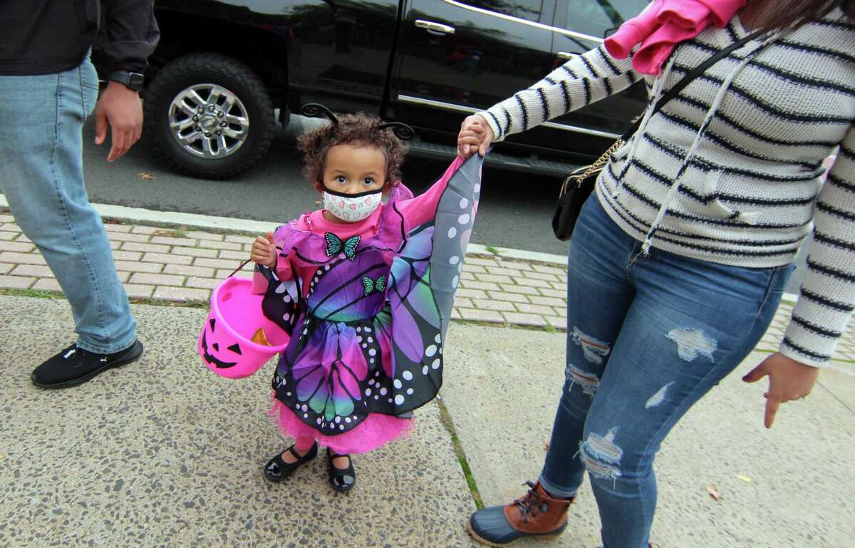 Local families wander through downtown Milford, Conn., taking part in a safe, socially distant way to enjoy the Halloween holiday on Saturday Oct. 24, 2020. Sponsored by Spinnaker Milford, participating shops put a scarecrow out front and offered treats to local kids.