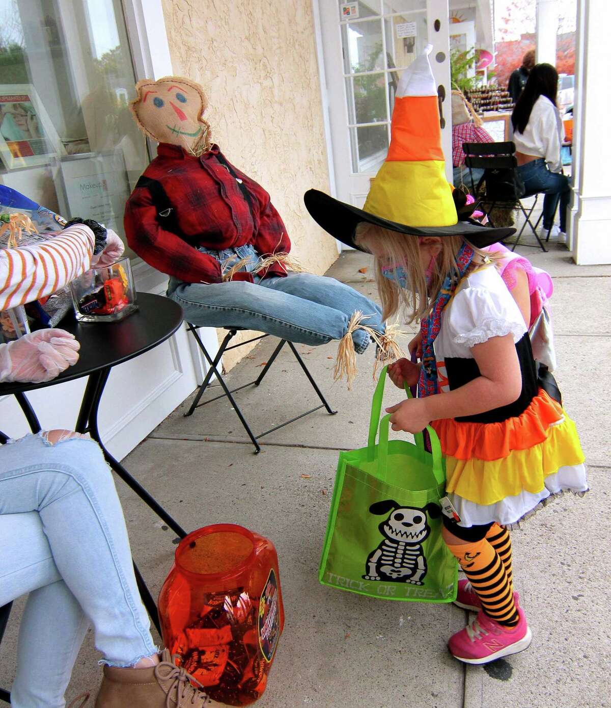 Local families wander through downtown Milford, Conn., taking part in a safe, socially distant way to enjoy the Halloween holiday on Saturday Oct. 24, 2020. Sponsored by Spinnaker Milford, participating shops put a scarecrow out front and offered treats to local kids.
