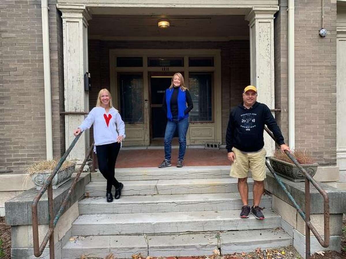 From left, Sue Utgaard, Lisa Allen and Dave Dipazo stand on the steps to the Haskell House in Alton, the planned site of a children’s museum. The project is waiting approval of a permit from the city so renovations may begin.