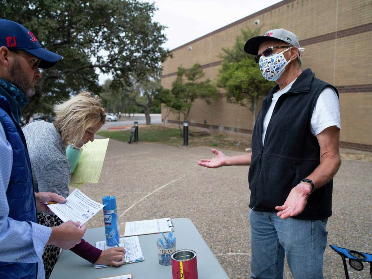 Terry Burns, Alamo Group chairman of the Sierra Club, right, speaks to voters as they sign petitions that call for accountability measures to be implemented at CPS Energy and the San Antonio Water System during the last week of early voting at Alzafar Shrine Auditorium, the mega voting site on the North Side on Saturday, October 24, 2020 in San Antonio, Tx., U.S. Burns said that they need 20,000 signatures on each measure to ensure they make it onto the Spring 2021 ballot. ?’We?•re trying to get these accountability measures on the ballot because people don?•t feel that the utilities are responsive,?“ Burns said. ?’The fact that our water rates keep going up the way they do. The fact that the Vista Ridge Pipeline was built without a vote. That that water is much more expensive than our local waterÉreally the rates are unfair with both utilities. They don?•t allow public input at all with CPS.?“