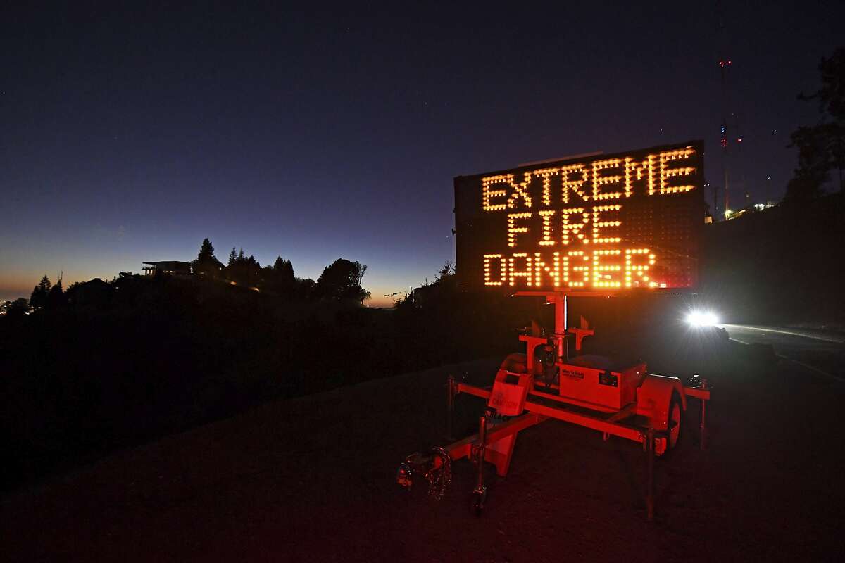 A roadside sign warns motorists of extreme fire danger on Grizzly Peak Boulevard, in Oakland on Sunday, Oct. 25, 2020. Because of high winds and dry conditions PG&E turned off the power to many customers all over Northern Califorina.