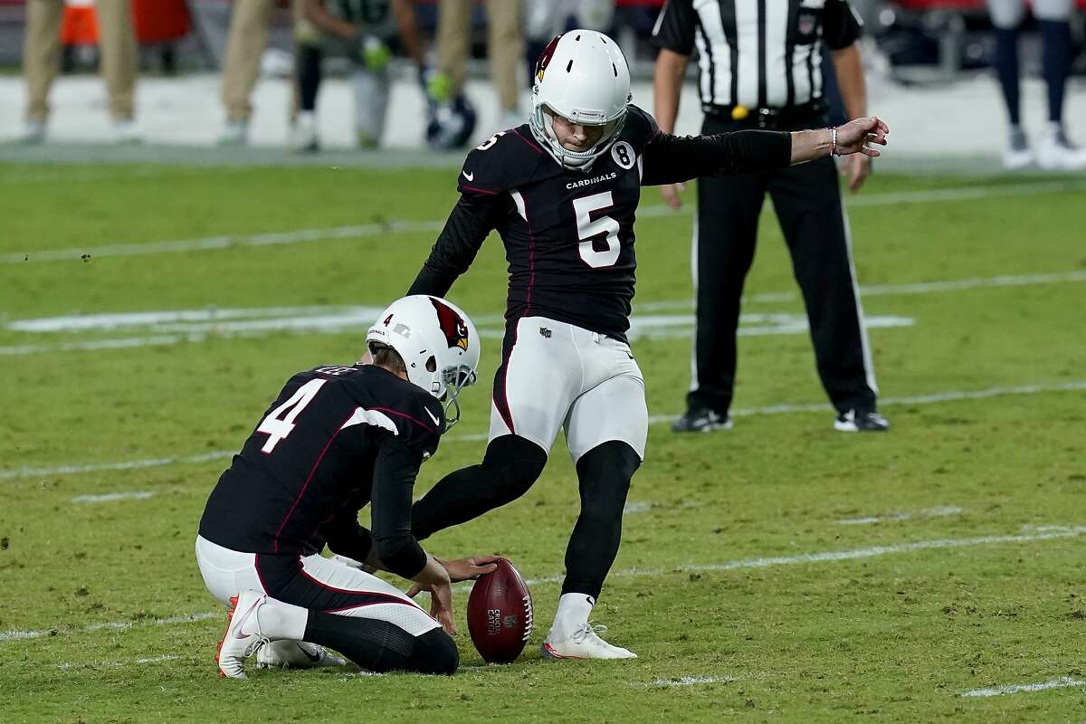 Arizona Cardinals kicker Zane Gonzalez (5) kicks the game winning field goal as punter Andy Lee (4) holds during the second half of an NFL football game against the Seattle Seahawks, Sunday, Oct. 25, 2020, in Glendale, Ariz. The Cardinals won 37-34 in overtime. (AP Photo/Ross D. Franklin)