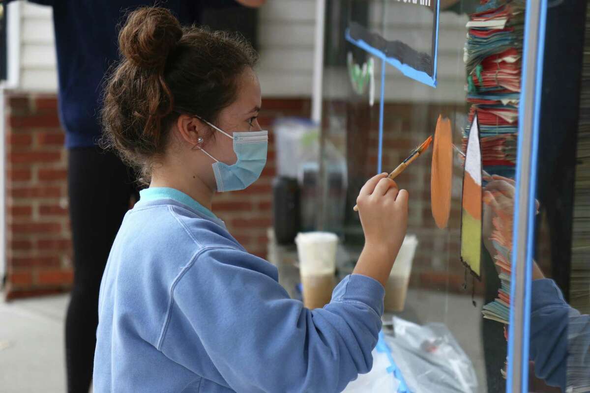Katie Koslow, 14, of Darien, works on the window at Kumon on the Post Road.