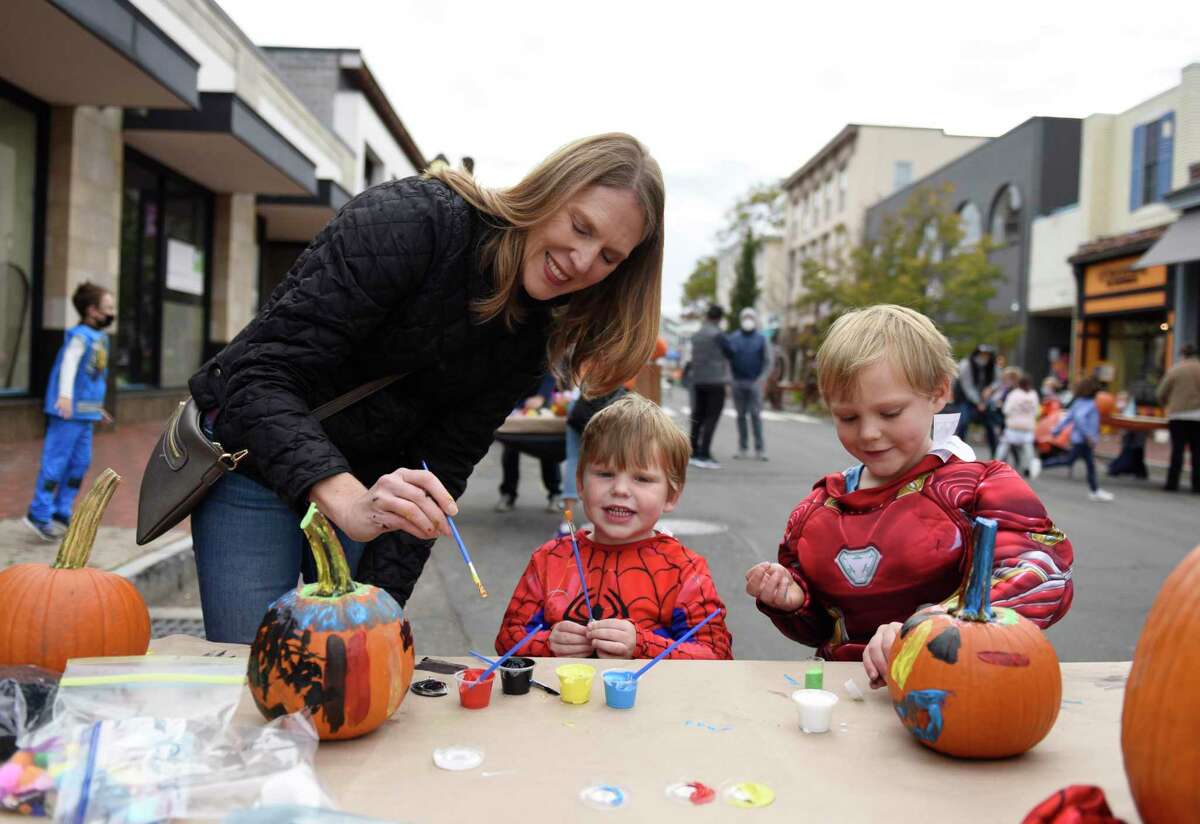 Westport's Lisa Akerson and her children Matthew, 3, and Andrew, 5, paint pumpkins at the Westport Downtown Merchants Association Halloween Family Pumpkinfest in Westport, Conn. Sunday, Oct. 25, 2020. 150 families dressed in Halloween costumes participated in the socially-distant pumpkin painting event, presented by the Westport Parks & Recreation and Westport Police Athletic League in partnership with the WDMA.