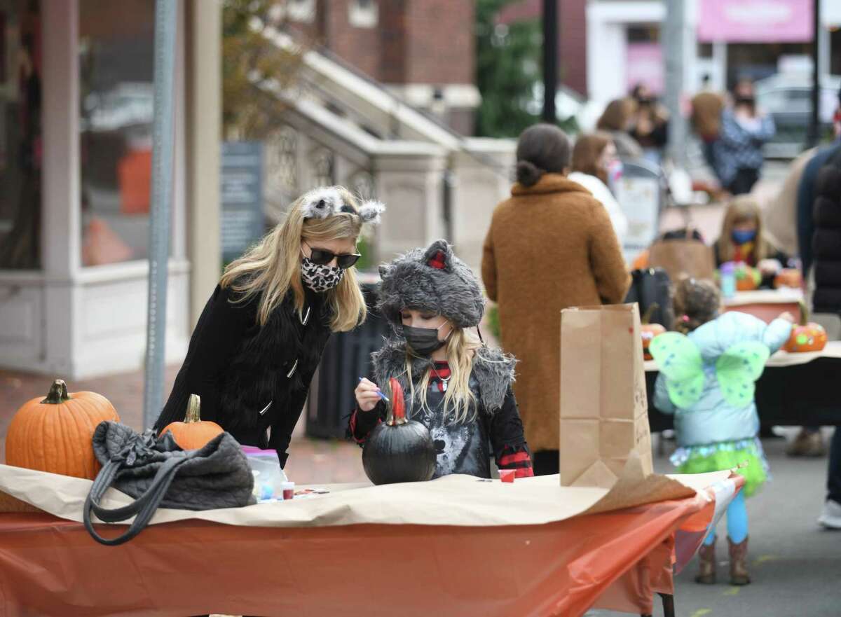 Southport's Pamela Scott and her daughter Hadley, 8, paint a pumpkin at the Westport Downtown Merchants Association Halloween Family Pumpkinfest in Westport, Conn. Sunday, Oct. 25, 2020. 150 families dressed in Halloween costumes participated in the socially-distant pumpkin painting event, presented by the Westport Parks & Recreation and Westport Police Athletic League in partnership with the WDMA.
