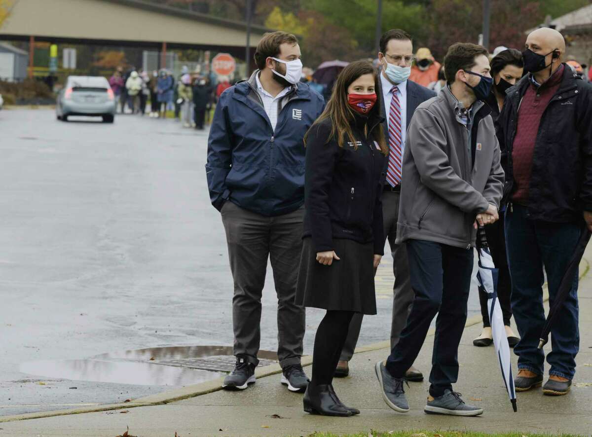 U.S. Rep. Elise Stefanik and her husband, Matt Manda, foreground right, wait in line to cast their ballots for early voting at Gavin Park in Saratoga Springs in October 2020. (Paul Buckowski/Times Union)