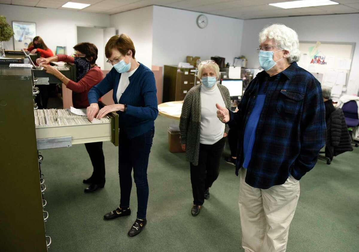 Seasonal election workers Lucille Limone, left, Meg Tocantins, second from left, Republican Registrar Lucy F. Corelli, and Democratic Registrar Ron Malloy help register voters and update existing registrations at the Registrar of Voters at the Government Center in Stamford on Monday.