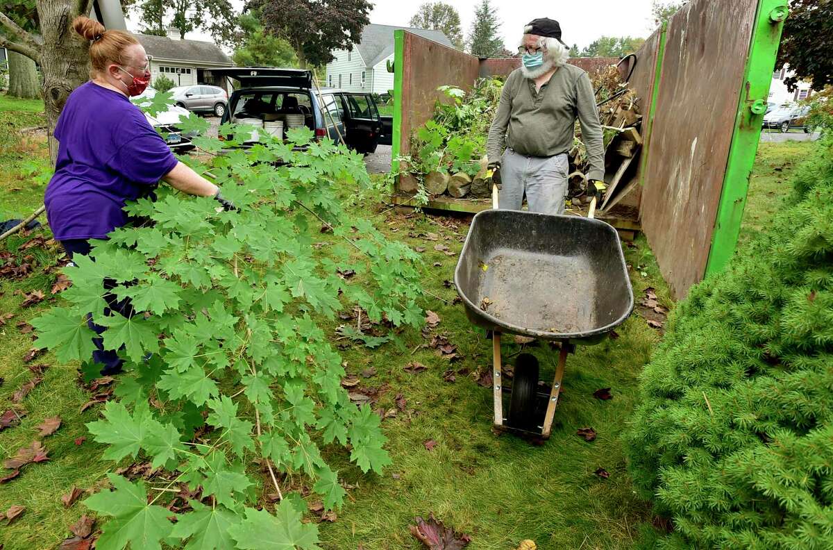Kelly Miller, left, and Allan (CQ) Wilcox, both of Milford, volunteer with the Milford Land Conservation Trust to cleanup a newly acquired 1.12 acre property with other land trust members at the end of Anchorage Drive Saturday in Milford.
