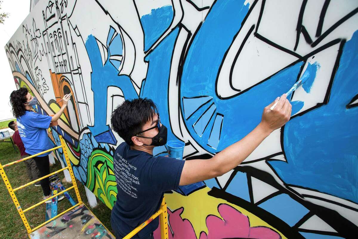 Student volunteers Frances Gallego, left, and Jefferson Ren help work on a mural, designed by graffiti artist Gonzo247, on the side of one of the temporary classrooms on the campus at Rice University Monday, Oct. 26, 2020 in Houston. The mural was commissioned as part of Rice's "Owl Together" week, a combination of homecoming and parents weekend, that is funded by Rice's office of development and alumni relations in conjunction with the Rice Public Art Program.