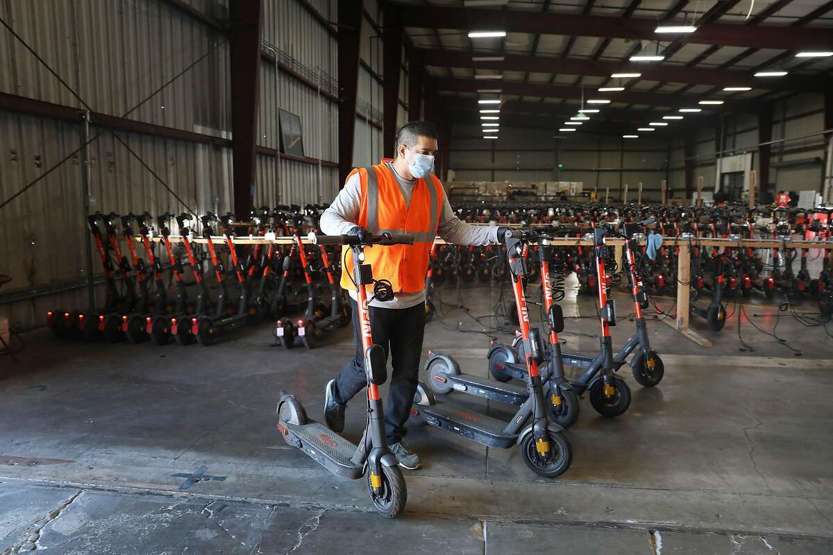 Michael Delgado, SPIN operations specialist, loads a van with SPIN scooters at a San Francisco warehouse before deploying them on Monday, October 19, 2020 in San Francisco, Calif.