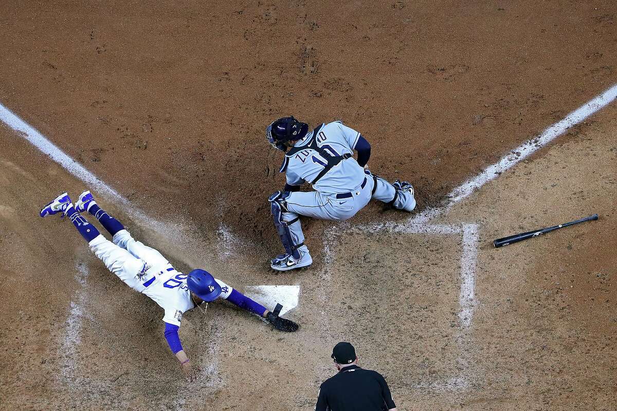 Mookie Betts slides home with the go-ahead run for the Dodgers in the in the #50 of the Los Angeles Dodgers slides in safely past Mike Zunino #10 of the Tampa Bay Rays to score a run on a fielders choice hit by Corey Seager (not pictured) during the sixth inning in Game Six of the 2020 MLB World Series at Globe Life Field on October 27, 2020 in Arlington, Texas. (Photo by Tom Pennington/Getty Images)