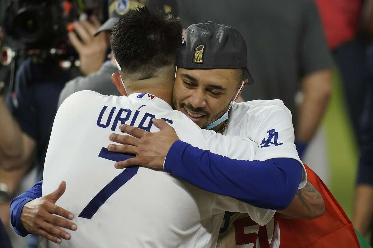 Los Angeles Dodgers pitcher Julio Urias and Mookie Betts celebrate after defeating the Tampa Bay Rays 3-1 to win the baseball World Series in Game 6 Tuesday, Oct. 27, 2020, in Arlington, Texas. (AP Photo/Eric Gay)