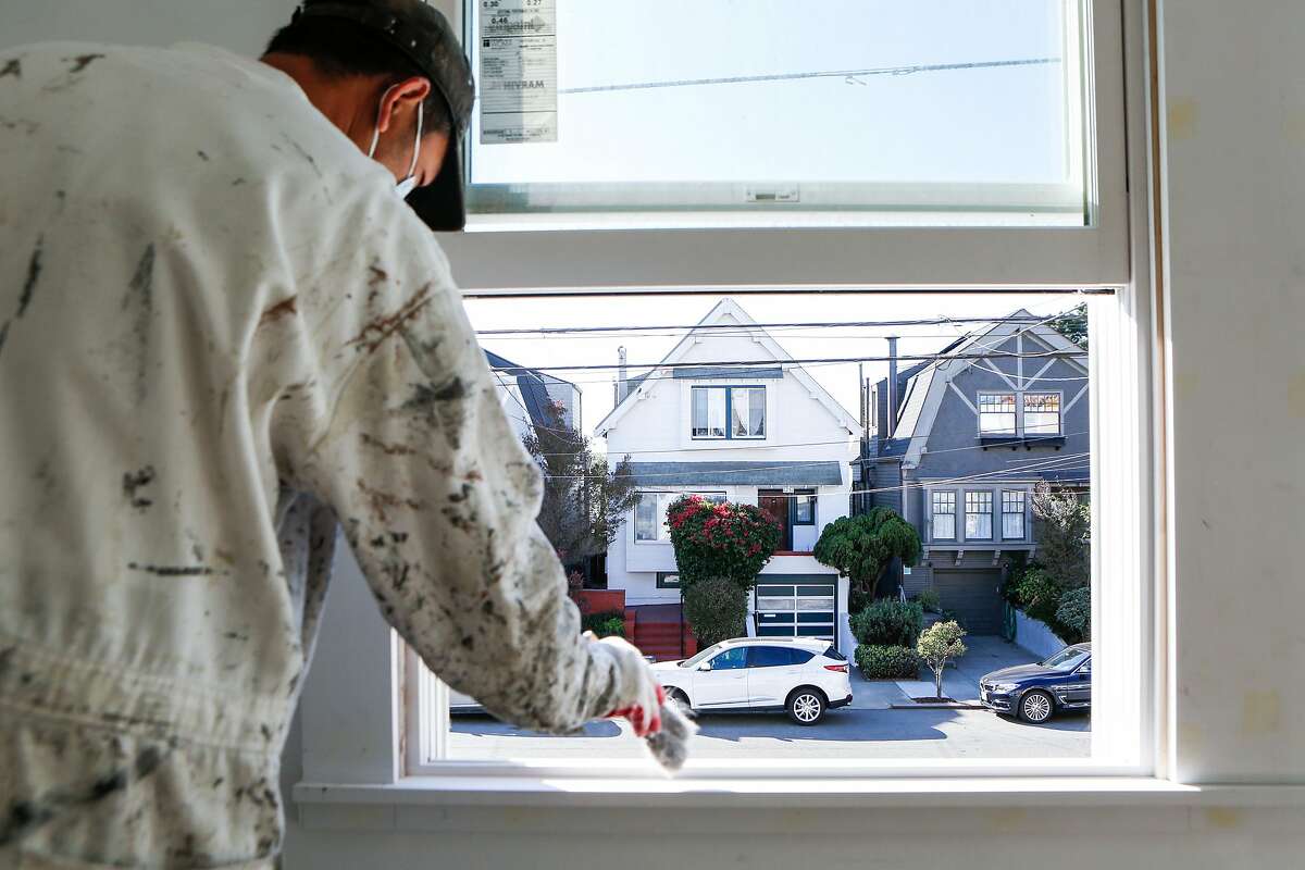 Yin Yang paints the interior of a single family home being renovated for sale in the Outer Sunset on Monday, October 26, 2020 in San Francisco, Calif.
