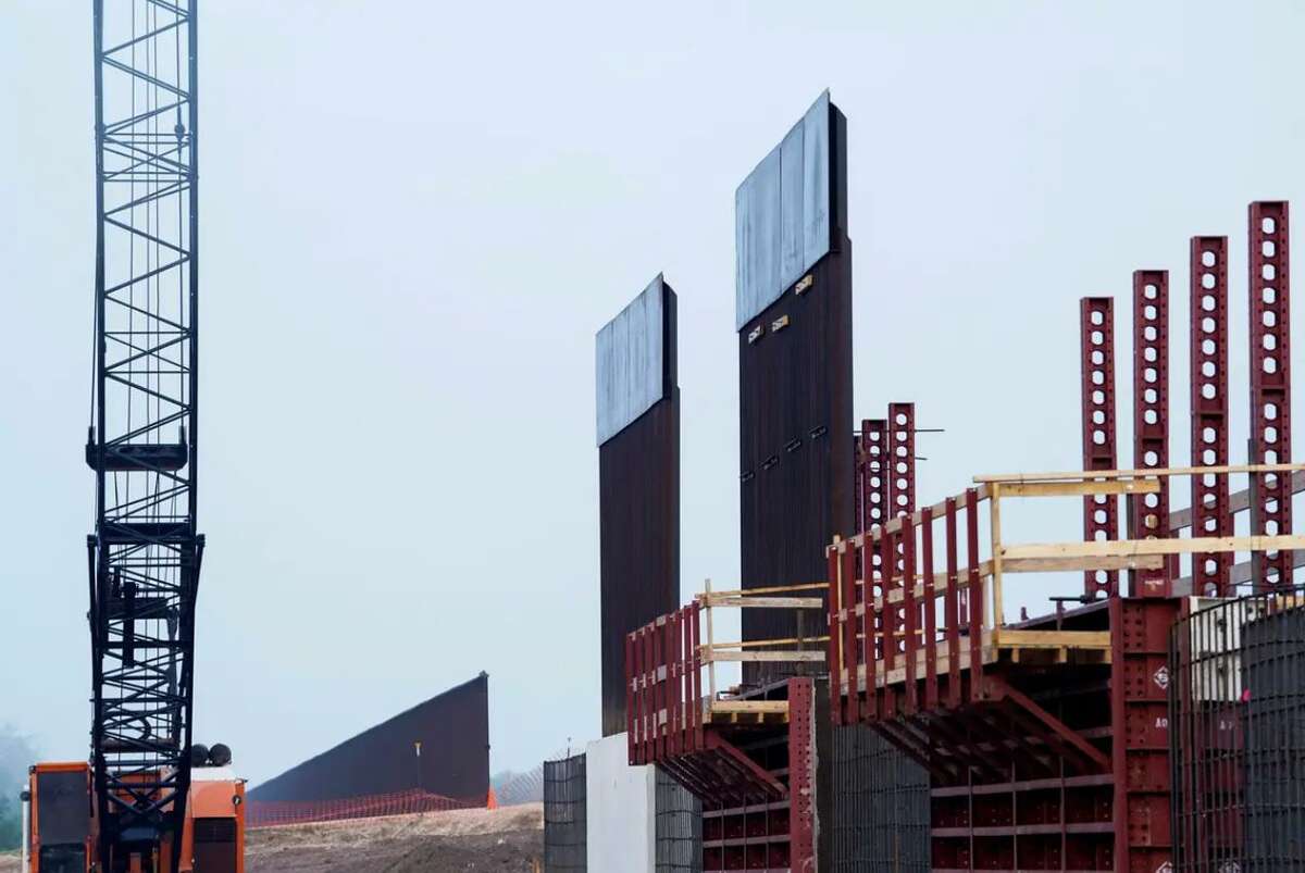 The existing border wall, at left, is shown as new segments of the border wall are erected in Texas near Donna in 2019.