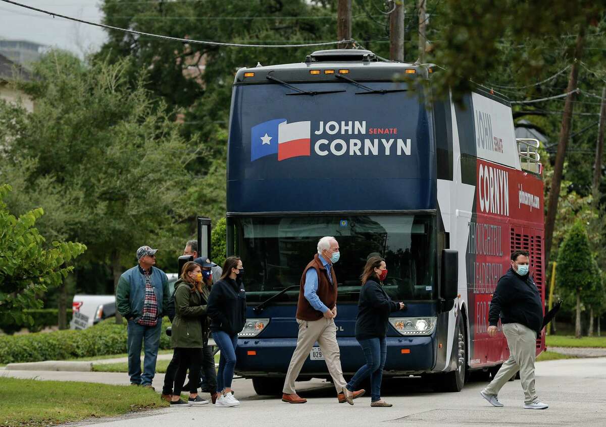 Sen. John Cornyn, center, gets off his Texas tour bus, while stopping at a "Back the Blue" event with Gov. Greg Abbott at the Houston Police Officer's Union Headquarters on Wednesday, Oct. 28, 2020, in Houston.