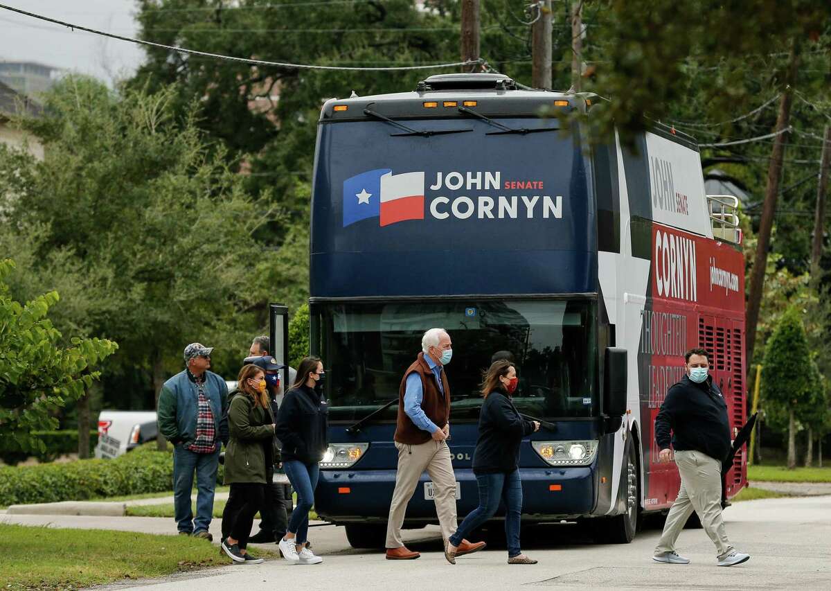 Sen. John Cornyn, center, gets off his Texas tour bus, while stopping at a "Back the Blue" event with Gov. Greg Abbott at the Houston Police Officer's Union Headquarters on Wednesday, Oct. 28, 2020, in Houston.