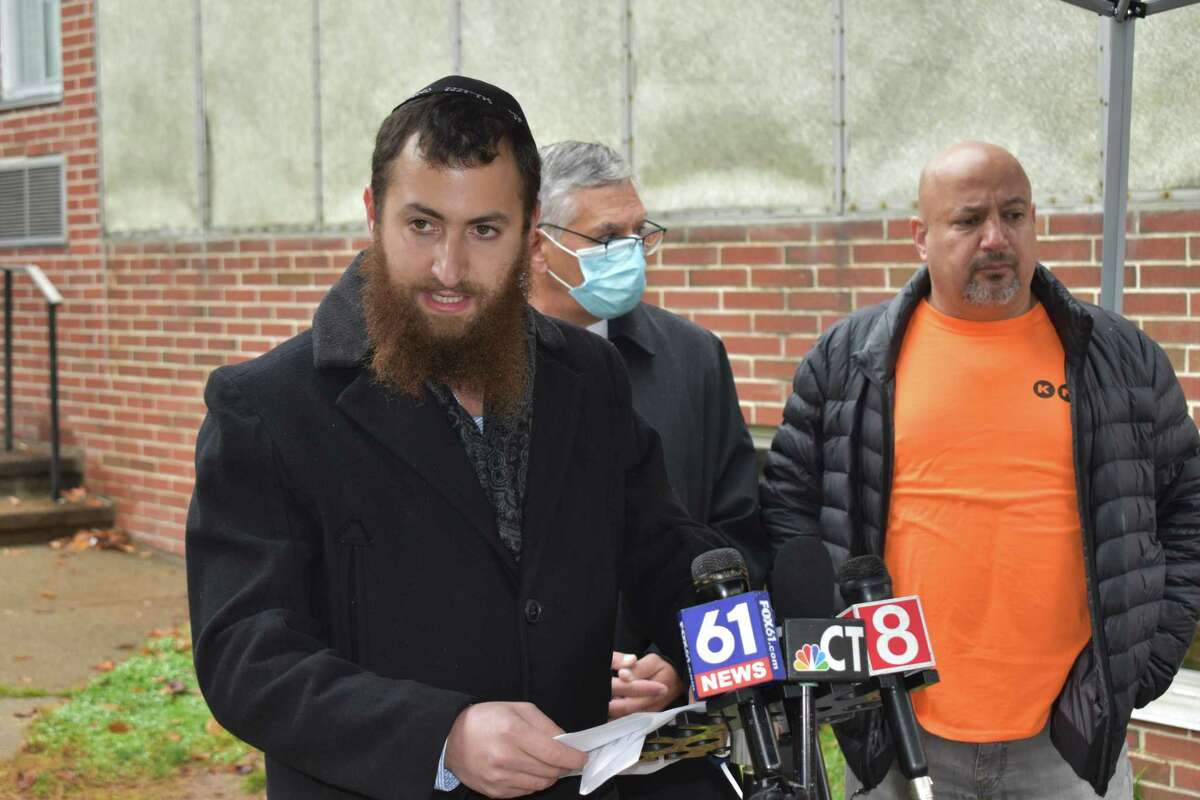 Residents of the Beaver Hills neighborhood in New Haven called for a greater police presence Wednesday after Nir Bongart was allegedly assaulted while riding his bike on Bellevue Road. Here, resident Avi Meer speaks, with state Sen. Len Fasano and Bongart in the background.