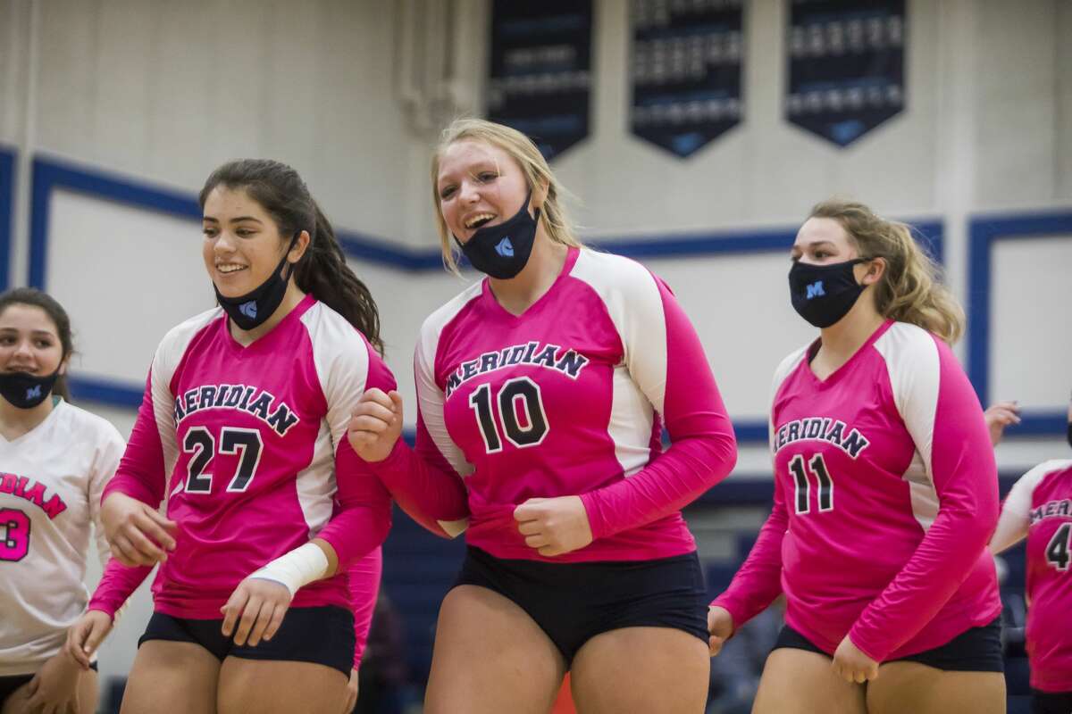 From left, Meridian's Jenna Holzinger, Izzy Dunn and Kelsey Merillat walk off the court after winning a match against Shepherd during a quad meet Wednesday, Oct. 28, 2020 at Meridian Early College High School. (Katy Kildee/kkildee@mdn.net)