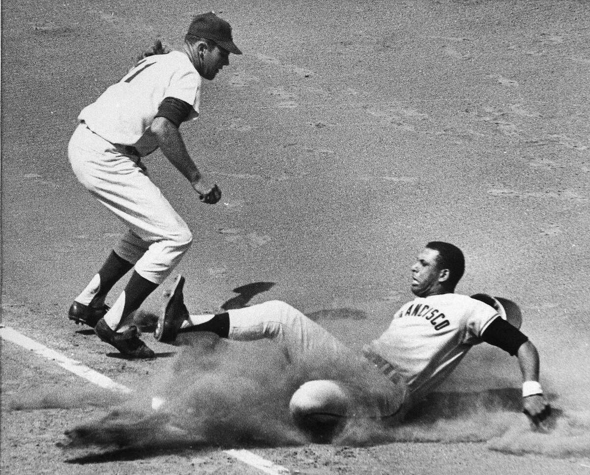 San Francisco Giants' first baseman Orlando Cepeda slides safely into third base as Los Angeles Dodgers' Ken McMullen covers the bag, Sept. 2, 1963.