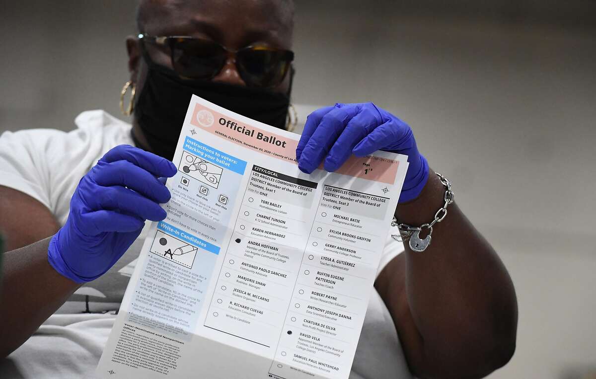 An election worker extracts mail-in ballots from their envelopes and examines the ballot for irregularities at the Los Angeles County Registrar Recorder’s mail-in ballot processing center in Pomona on Oct. 28, 2020.