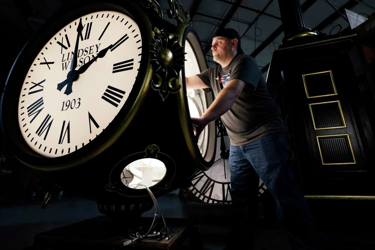 Dan LaMoore works on a Seth Thomas Post Clock at Electric Time Company, Friday, Oct. 23, 2020, in Medfield, Mass.