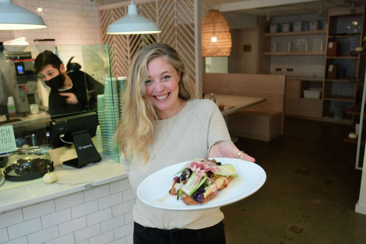 Molly Healy, owner of Manna Toast, an artisan toast cafe, with Hummus on Sourdough, Friday, October 23, 2020, in Westport, Conn. The eatery opened during the pandemic with great success.
