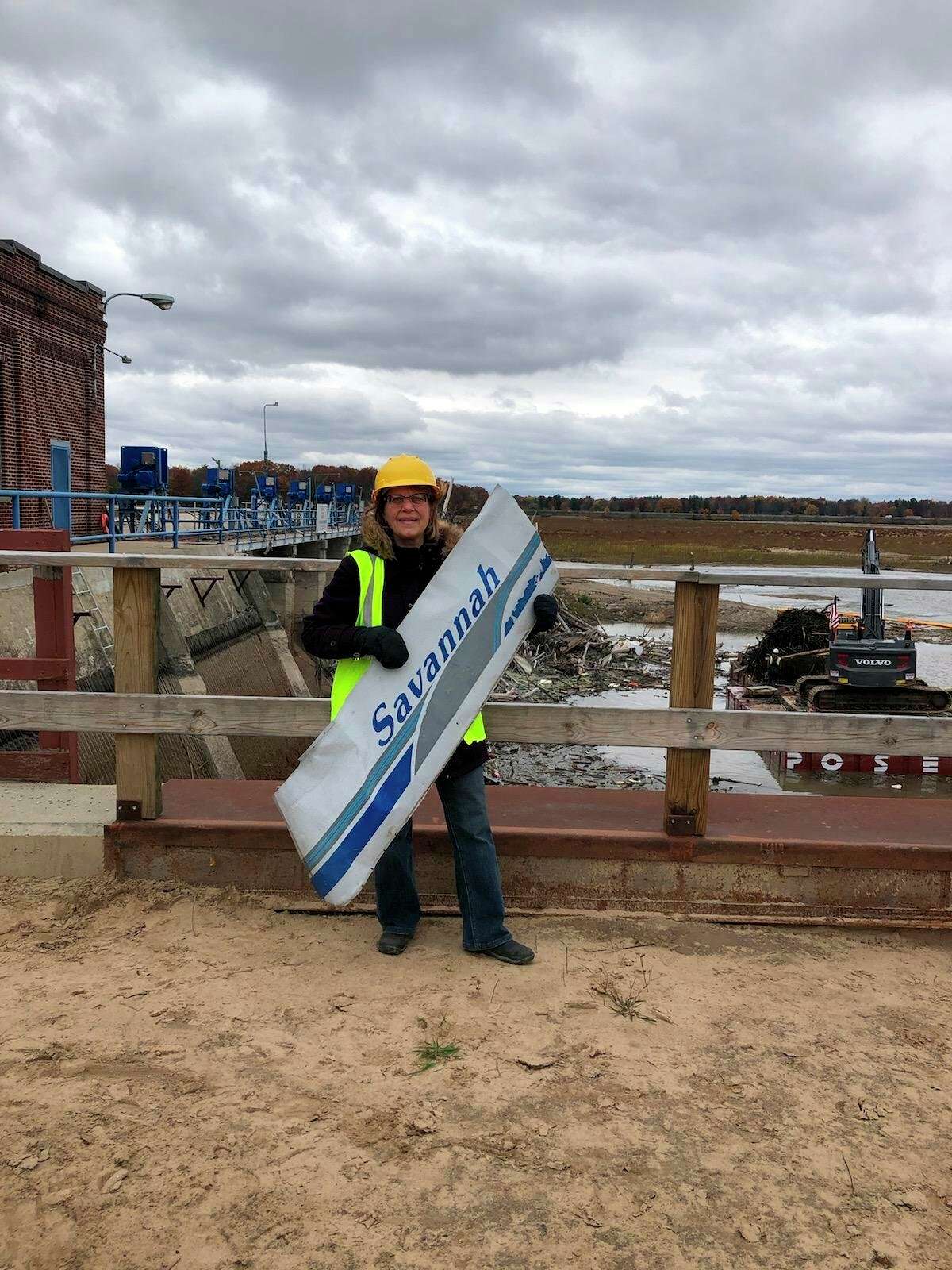 Dolores Porte holds the "Savannah" sign that was salvaged from her Crest Savannah pontoon boat that was removed from the water near the Sanford Dam on Thursday. (Photo provided/Dolores Porte)