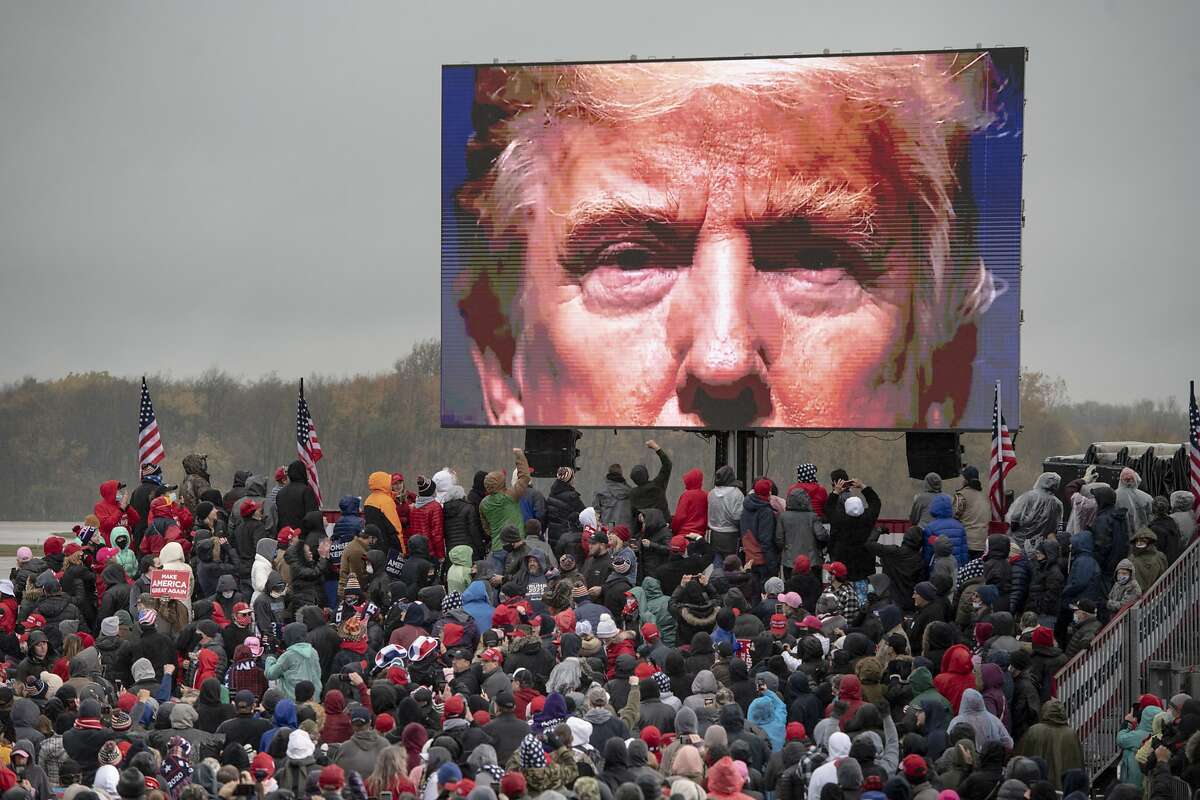 Supporters of President Trump watch a video during a campaign rally Tuesday in Lansing, Mich. Instead of talking about his plan if re-elected, Trump criticized his rival, Joe Biden.