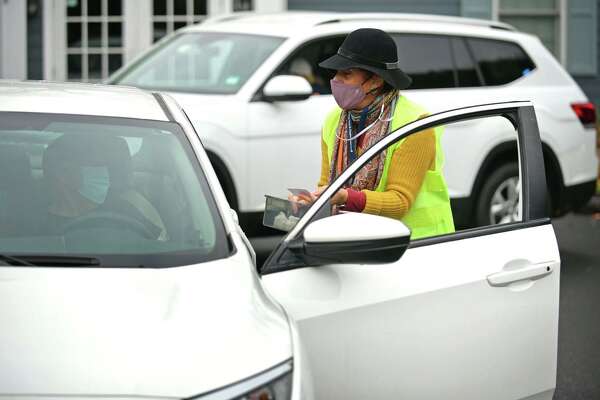 Nurse Margarita Shapiro checks an insurance card during a drive-thru flu shot clinic Oct. 28 at Visiting Nurse &amp; Hospice of Fairfield County in Wilton.