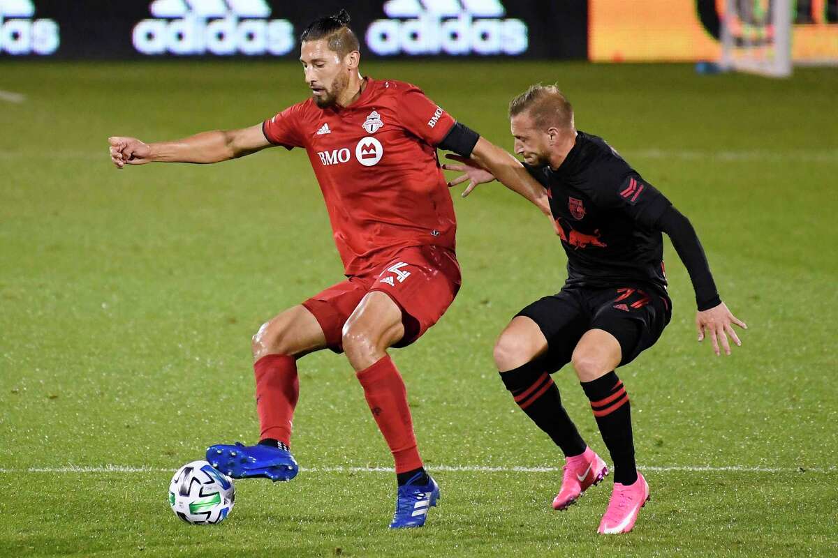Toronto FC’s Omar Gonzalez, left, controls the ball as New York Red Bulls’ Daniel Royer defends earlier this month at Rentschler Field.