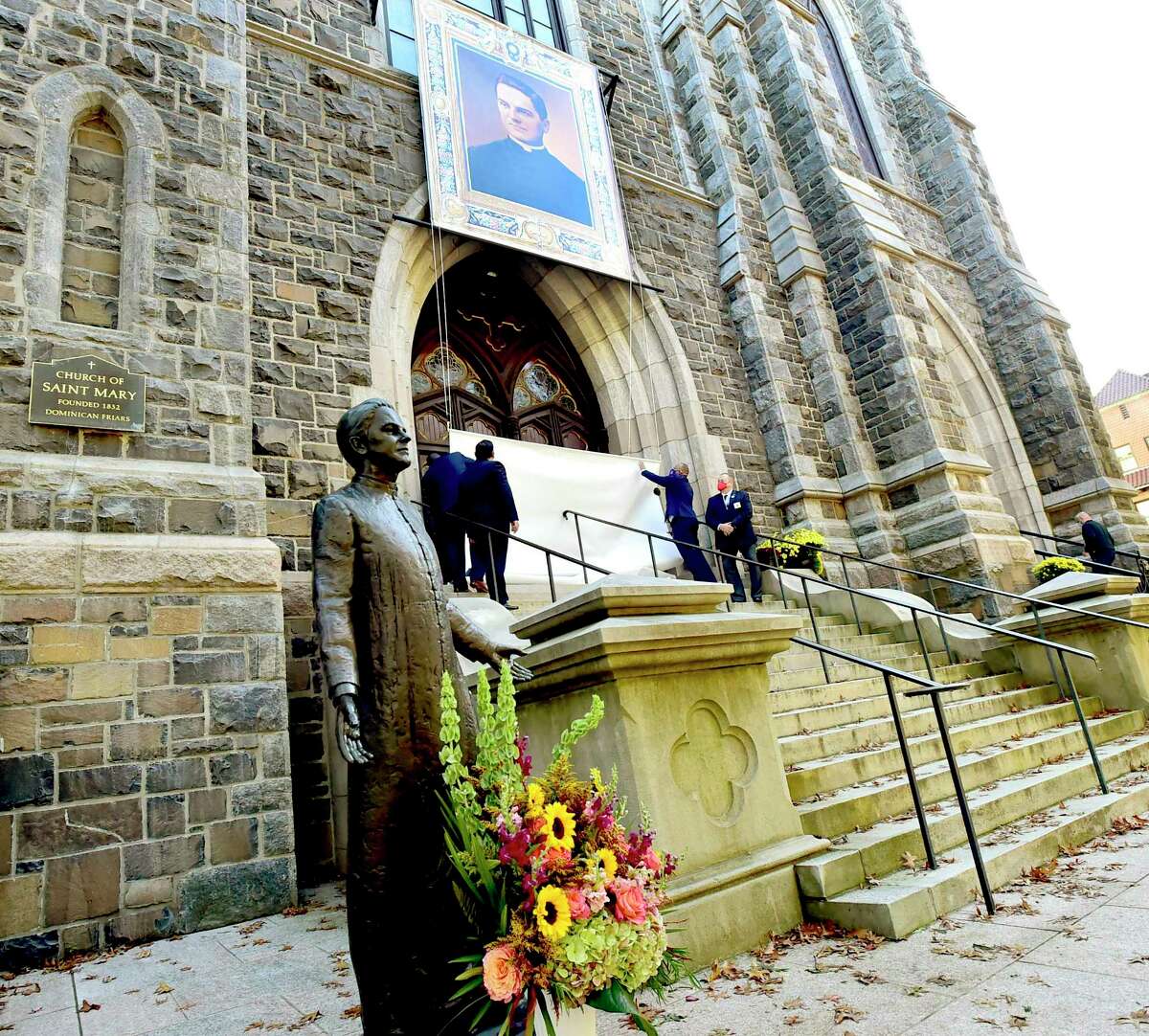 New Haven, Connecticut - Friday, October 30, 2020: A portrait of Rev. Michael J. McGivney is unveiled Saturday in front of St. Mary's Church in New Haven during a Beatification Mass for McGivney, founder of the Knights of Columbus. The mass is video streamed from the Cathedral of St. Joseph in Hartford around the world and also televised at St. Mary's Church in New Haven as the Catholic Church Saturday declared Father McGivney, "blessed", which, in the Catholic Church, is one step from canonization as a saint. McGivney died in 1890. McGivney’s tomb is in the rear of St. Mary, which is undergoing renovation and is closed because of the coronavirus pandemic. Pope Francis announced Wednesday that he recognized a 2015 miracle attributed to McGivney’s intercession, beatifying him. A second miracle is required to elevate McGivney to sainthood.