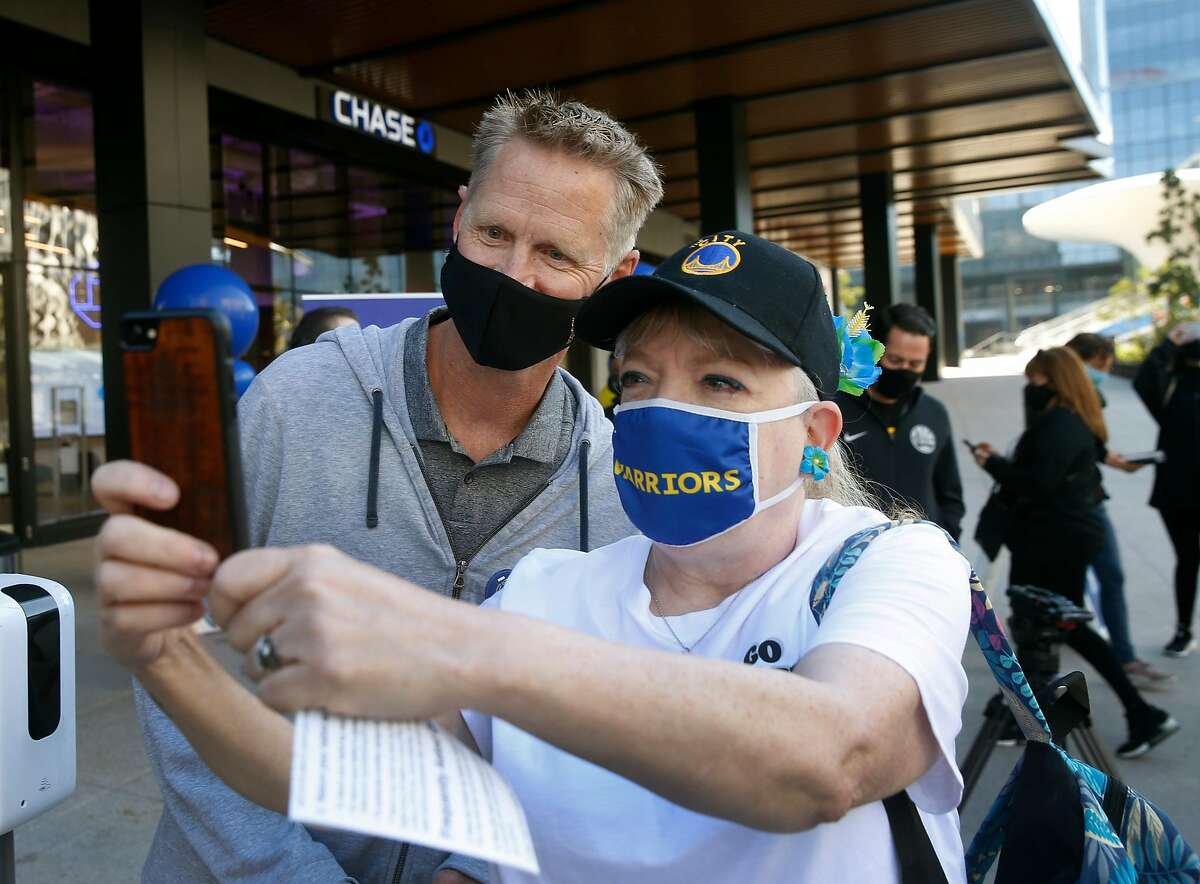 Golden State Warriors head coach Steve Kerr poses for a selfie with Candi King at a walk-up ballot collection point at Chase Center in San Francisco.