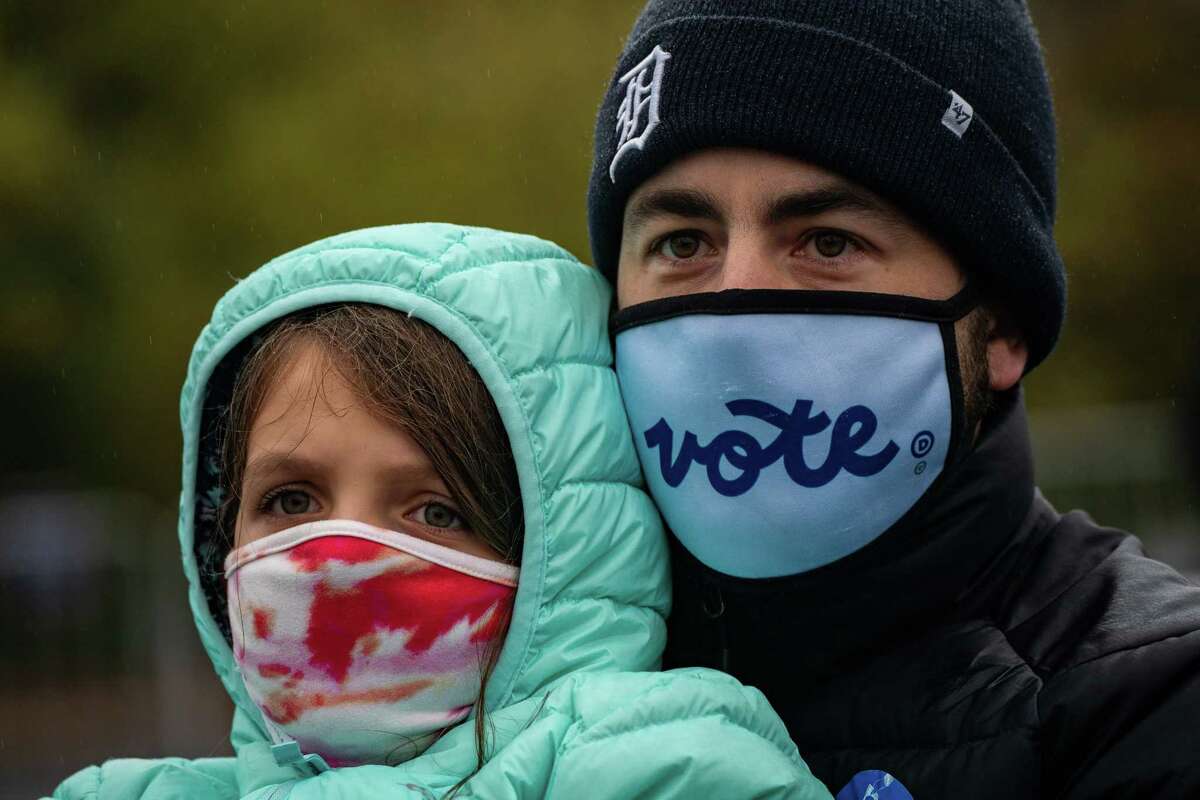 Andrew Poole, 37, and his daughter Elliot Poole, 6, attend a canvass launch in support of Joe Biden at the Michigan Education Association in East Lansing, on Thursday, Oct. 29, 2020.