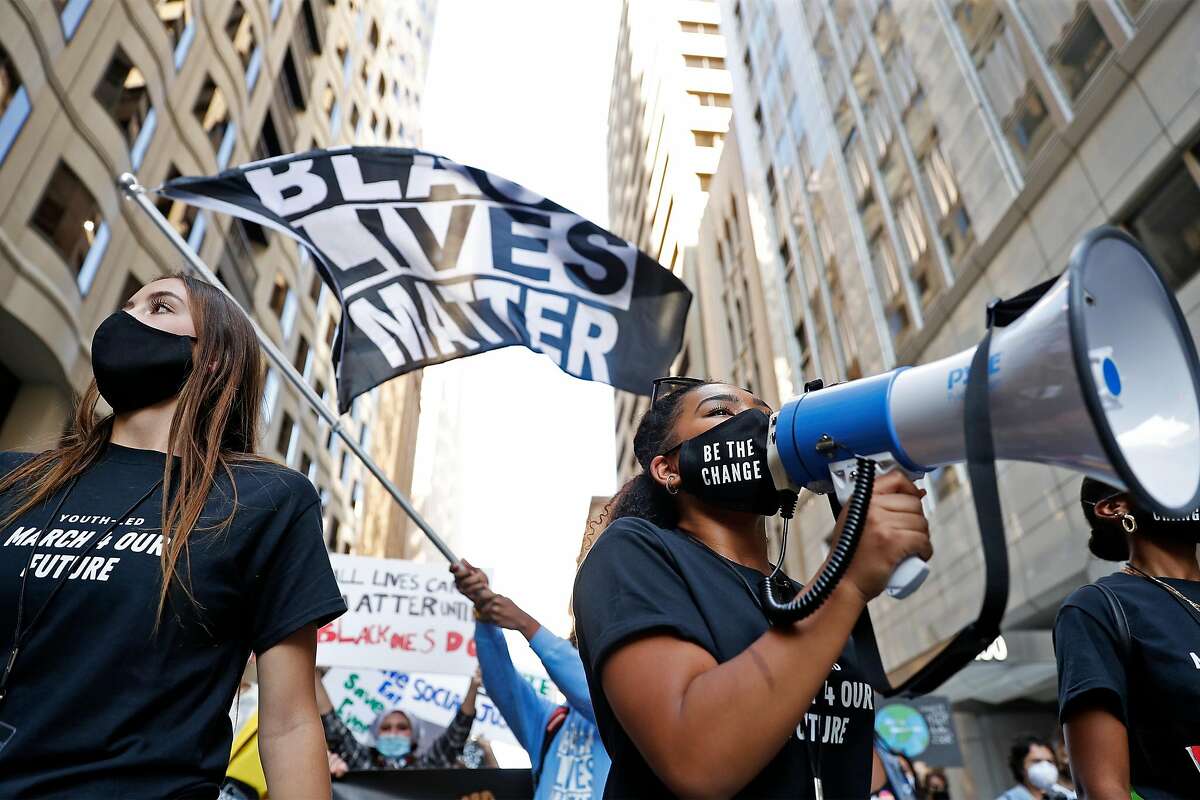 Tiana Day (right) leads the “March 4 Our Future” down Montgomery Street in San Francisco on Sunday.