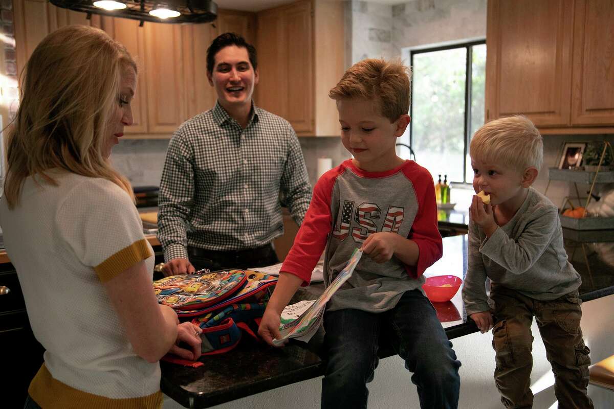 Max McGuire, 6, shows his drawing to his parents, Aubra and Ryan McGuire, as his brother, Rhett, 3, watches at their home in San Antonio on Friday. The family is among more than 11 million Americans who purchase their health insurance through the Affordable Care Act’s federal and state marketplaces.