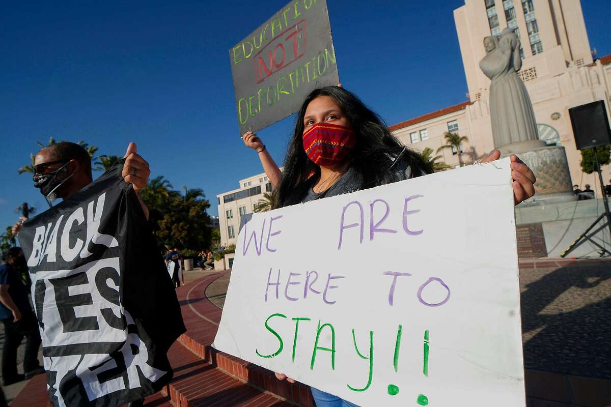 People hold signs during a rally in support of the Deferred Action for Childhood Arrivals program in San Diego last June. California and other states have sued to allow new applicants to the immigration program.