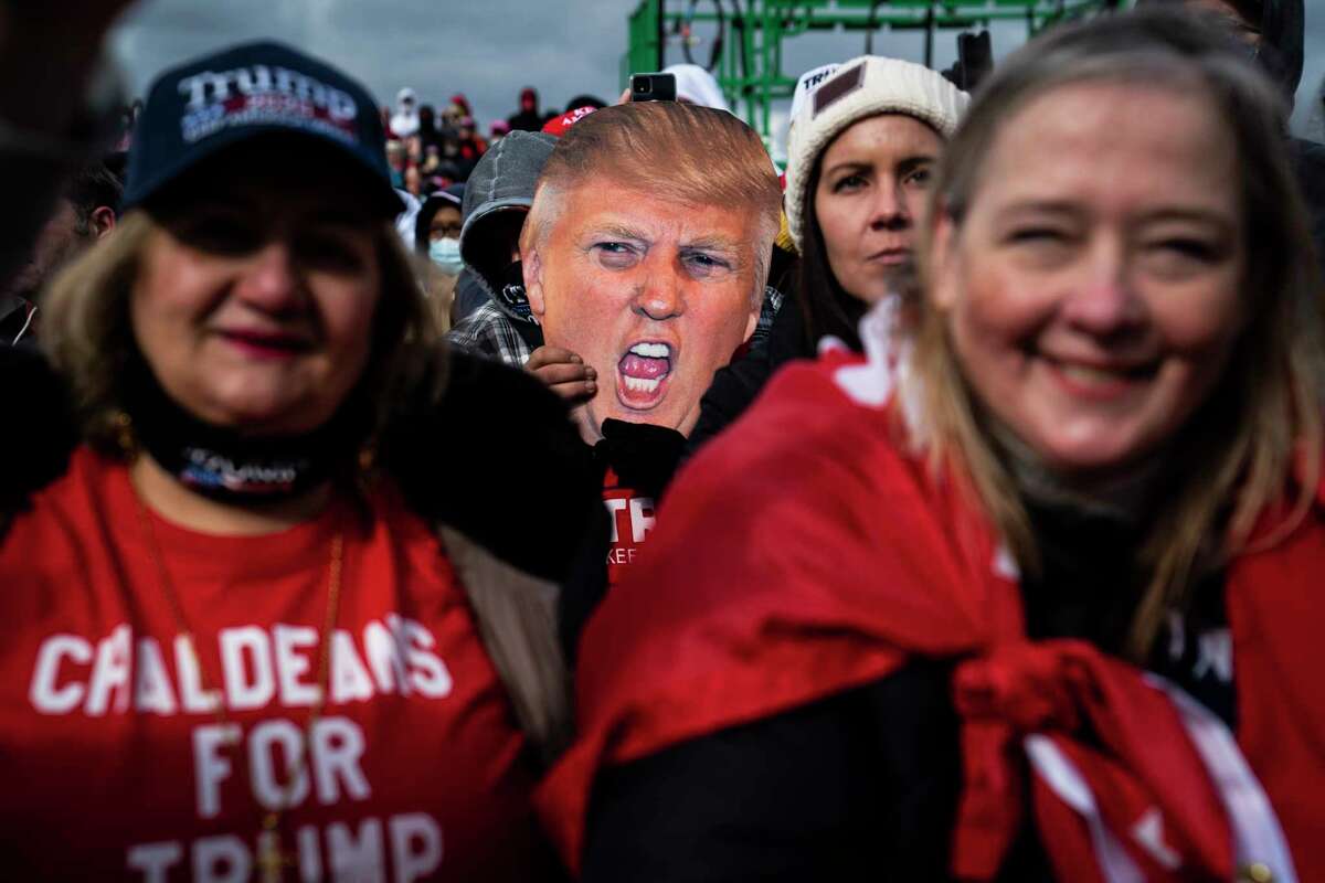 Supporters cheer as President Donald Trump speaks during a rally in Washington, Mich., on Sunday, Nov. 1.