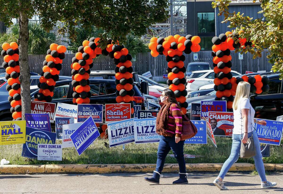 People walk past the Metropolitan Multi-Service Center during the last day of early voting Friday, Oct. 30, 2020, in Houston.