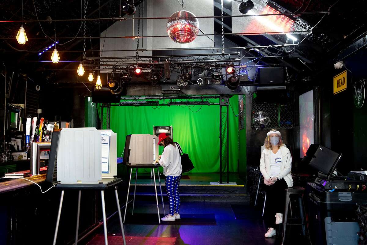 Christine Malvin (center) casts her vote under a disco ball at the Eagle.