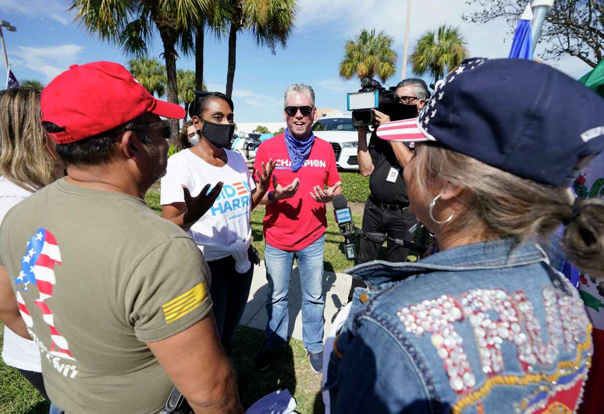 Laurie Robinson, a Biden supporter, second from left, has a friendly conversation with Tex Christopher, center, and other Trump supporters outside the polling location at Metropolitan Multi-Services Center, 1475 West Gray St., Tuesday, Nov. 3, 2020 in Houston.