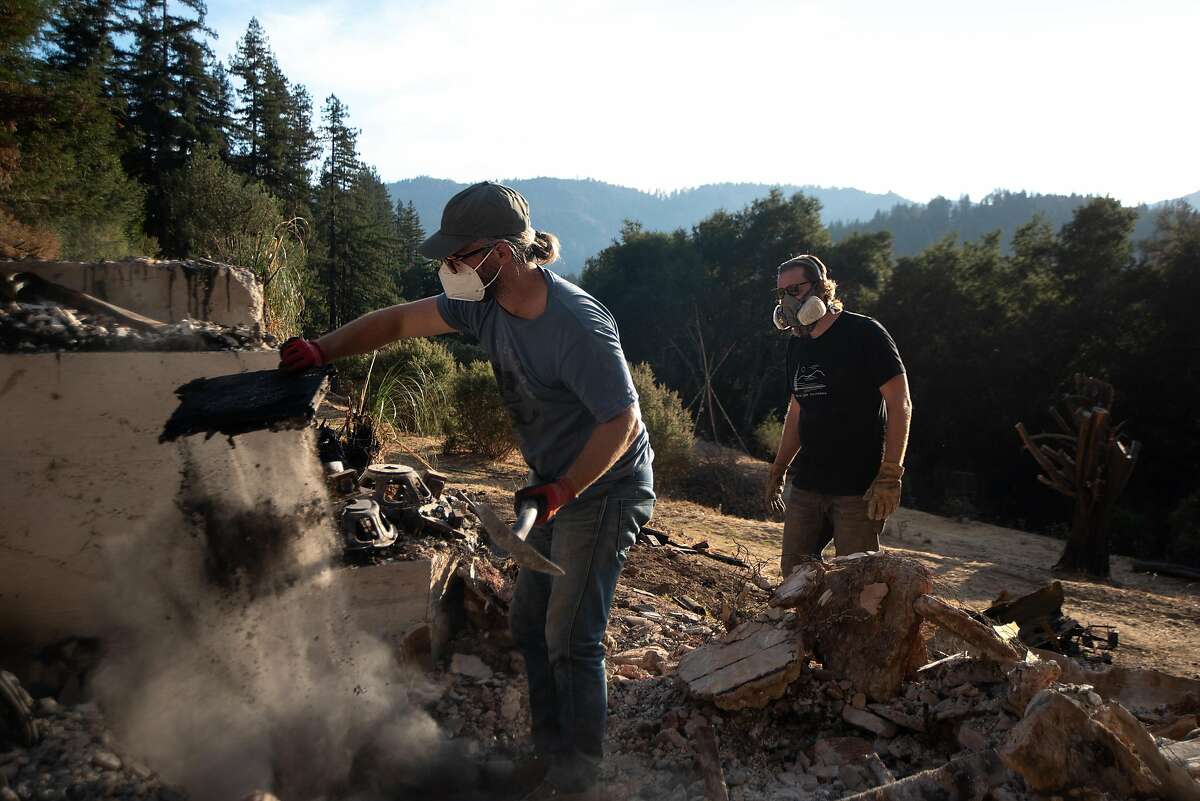 Jon Payne (right) and Chris Jones, his band mate in Wolf Jett, sift through the wreckage of Jon and Elizabeth Payne's house in Boulder Creek.